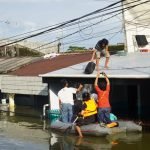 Warga di Blok 8, Perumnas Antang, Kecamatan Manggala, memakai perahu karet menyusuri genangan banjir/Muh. Syawal - Bollo.id