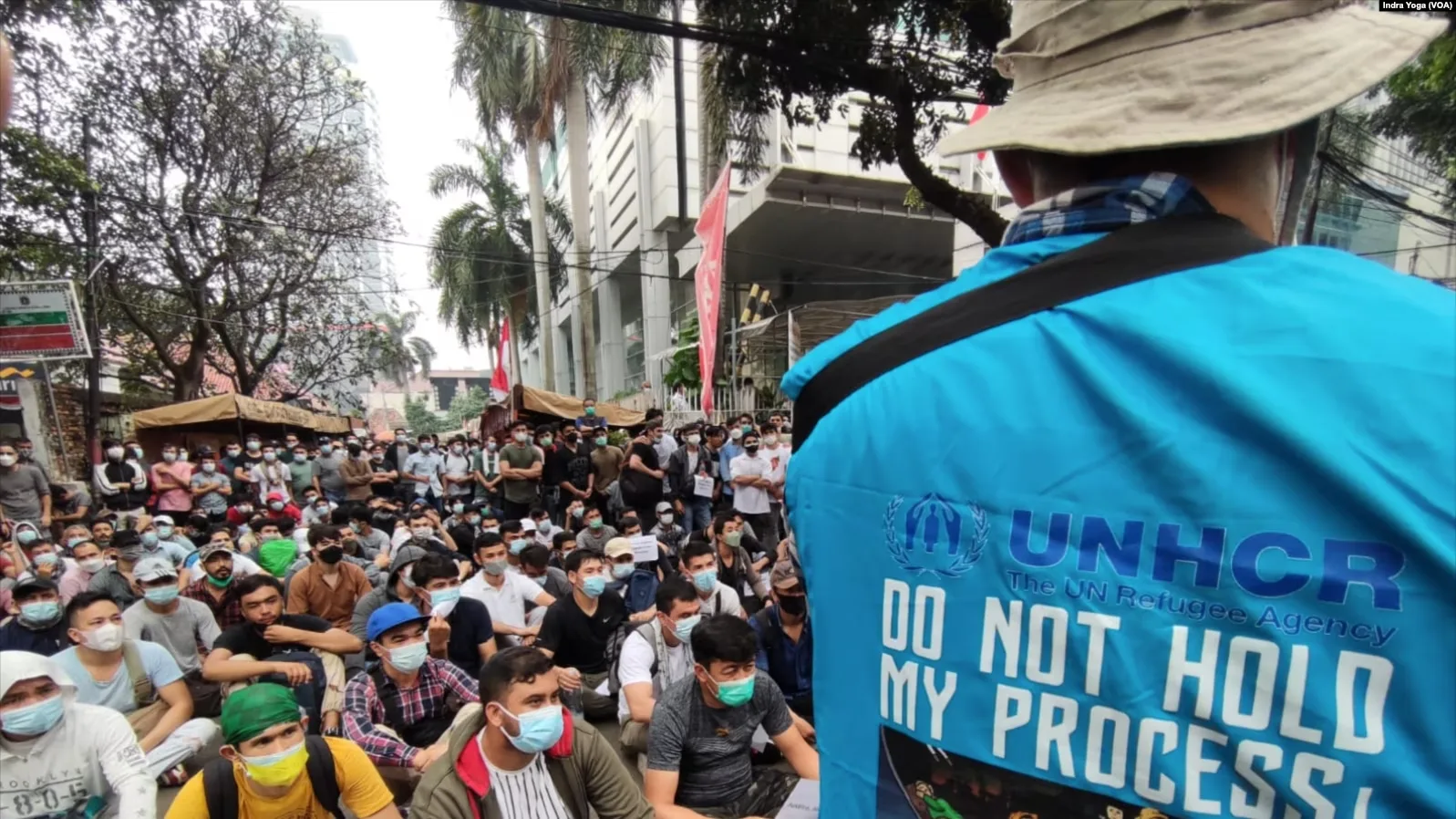 Para pengungsi dari Afghanistan menyampaikan suara mereka sementara polisi mengawasi mereka di depan kantor UNHCR, Jakarta, 24 Agustus 2021. (Foto: VOA/Indra Yoga)