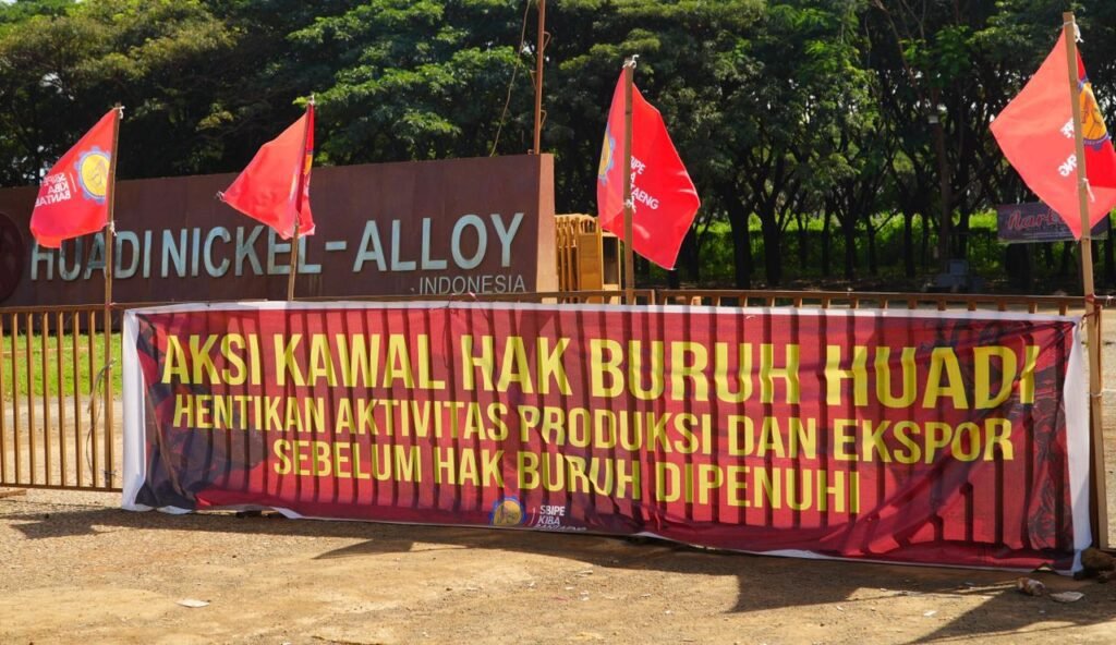 Spanduk protes buruh yang terpampang di pagar PT Huadi Nickel Alloy/Foto: Arya Nurprianugraha