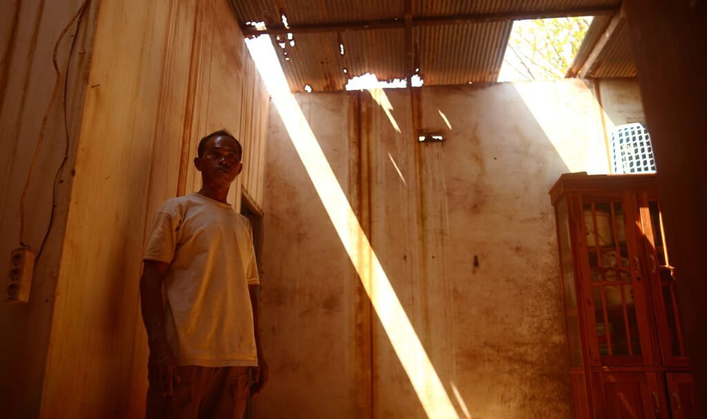 Warga Borongloe, Amiruddin saat menunjukkan atap dapur rumahnya yang bocor. Rumahnya hanya berjarak 105 meter dari tembok perusahaan/Arya Nur Prianugraha untuk Bollo.id.