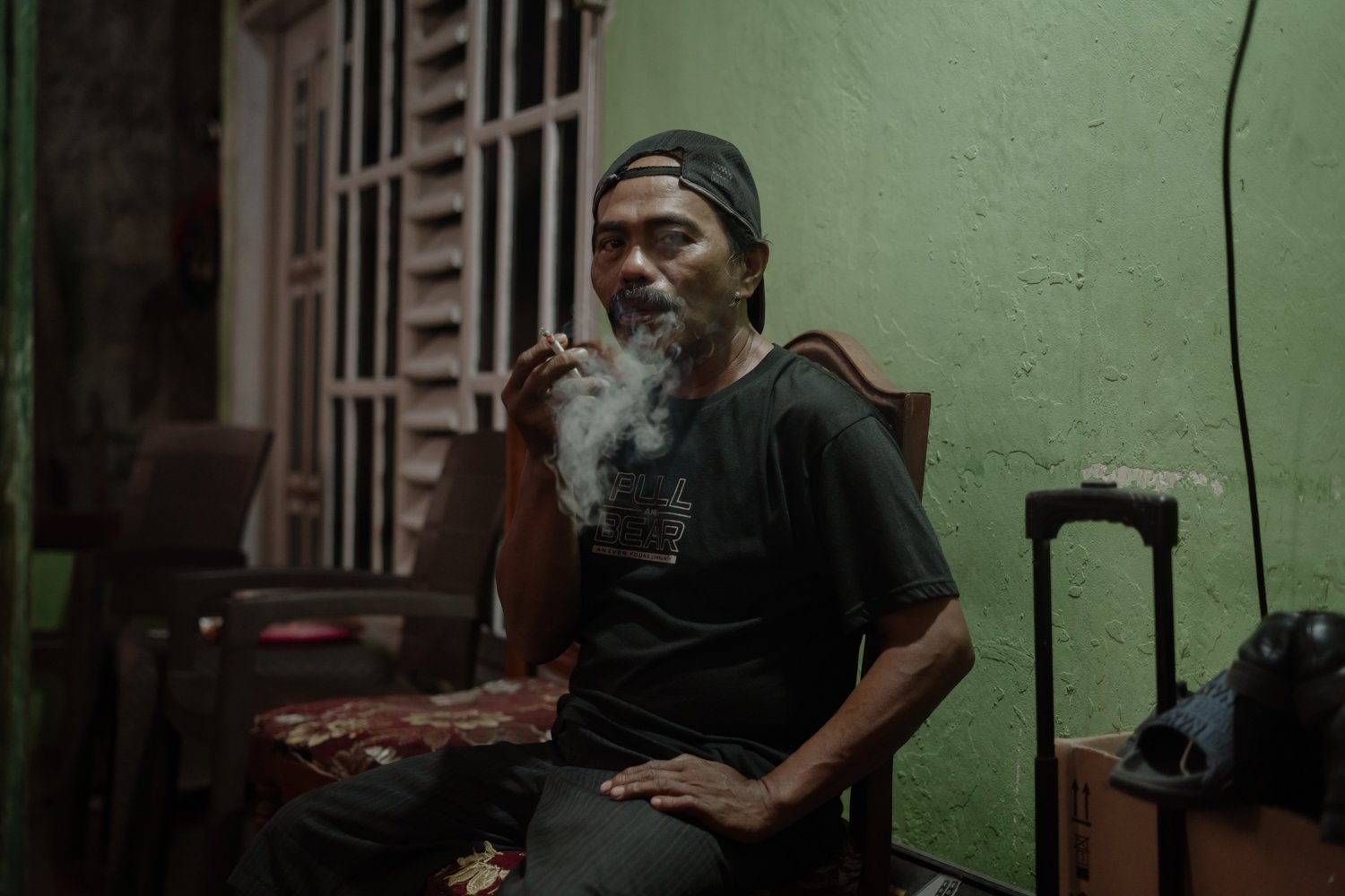 Nur yang duduk di depan teras rumahnya./Aziziah Diah Aprilya untuk Bollo.id