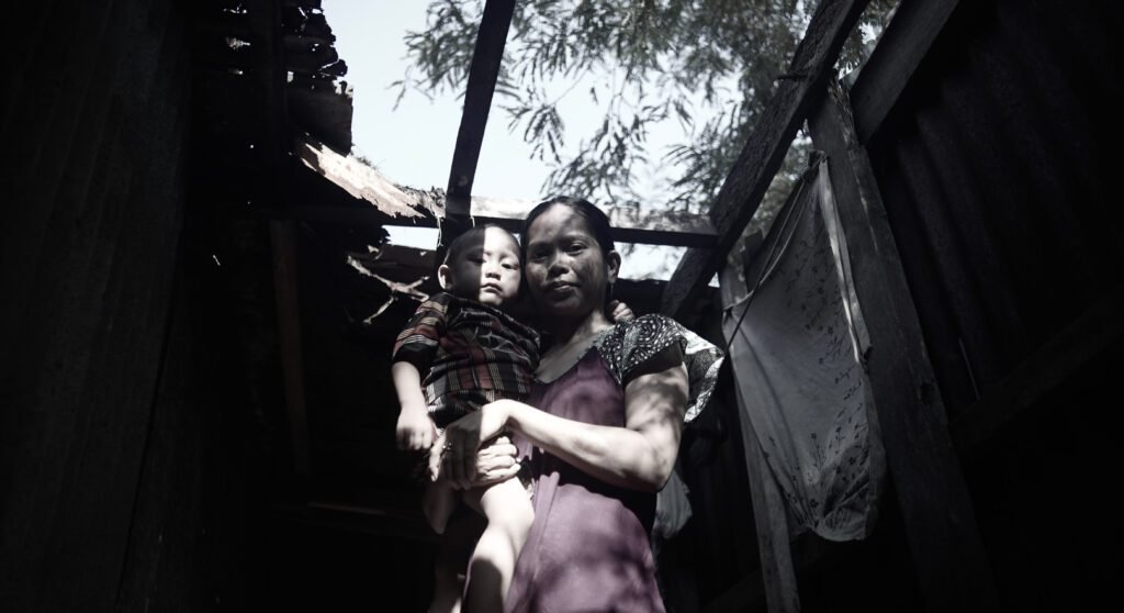 Narti menggendong anaknya, Rayyan di kamar mandi. Atap kamar mandinya tanggal karena keropos/Arya Nur Prianugraha untuk Bollo.id.