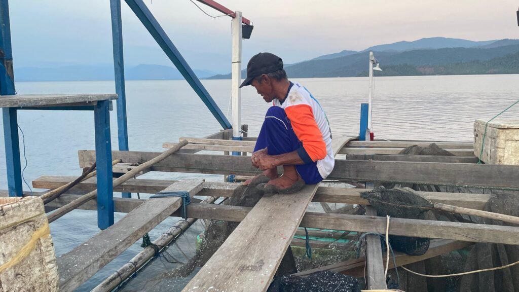 Rustam, nelayan di Desa Harapan Kecamatan Malili Luwu Timur sedang menjahit jaring yang rusa pada 15 Oktober 2025. Foto: Andini/Bollo.id